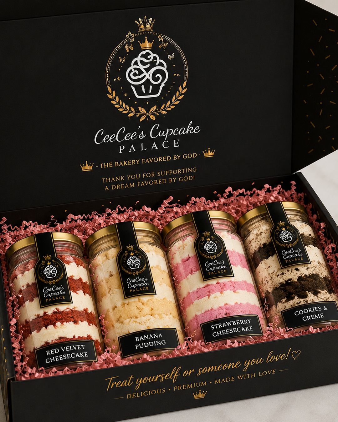 Open gift box with four Cee Cee's Cupcake Palace cupcake jars: Red Velvet Cheesecake, Banana Pudding, Strawberry Cheesecake, Cookies & Creme